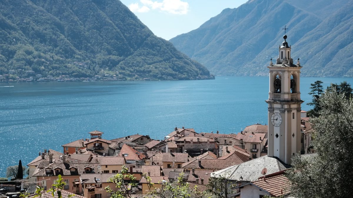 Stunning view of Lake Como from the village with a prominent bell tower against mountainous backdrop.